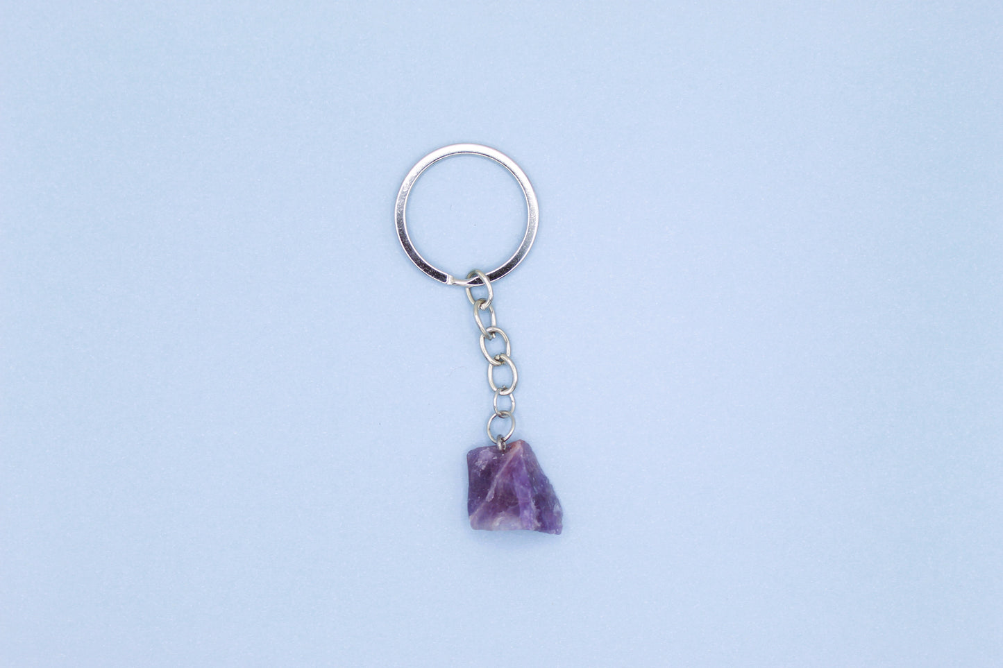 Keychain with a purple stone on a light blue background