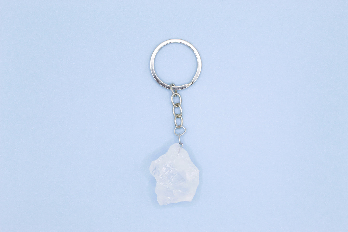Keychain with a white stone pendant on a light blue background