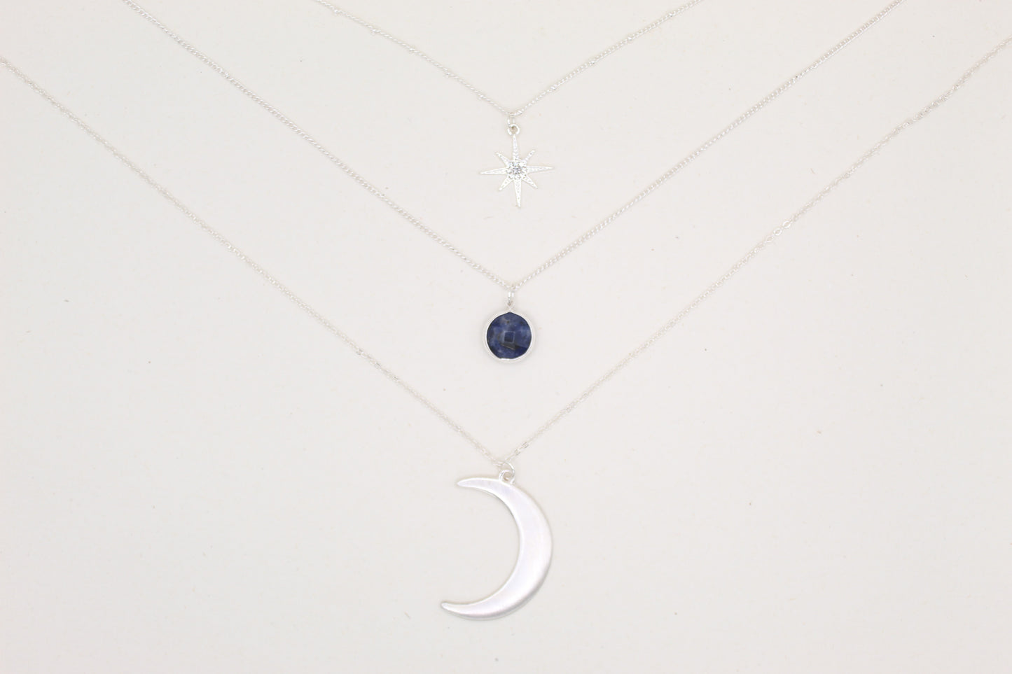 Necklace with a moon-shaped pendant on a light gray background