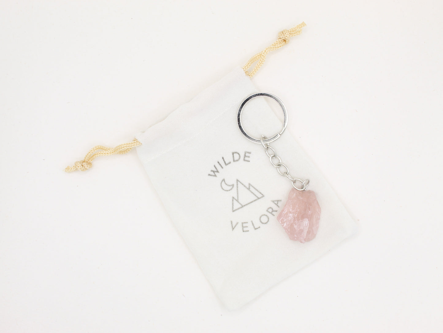 Keychain with pink stone and 'Wilde Velora' branding on a white background