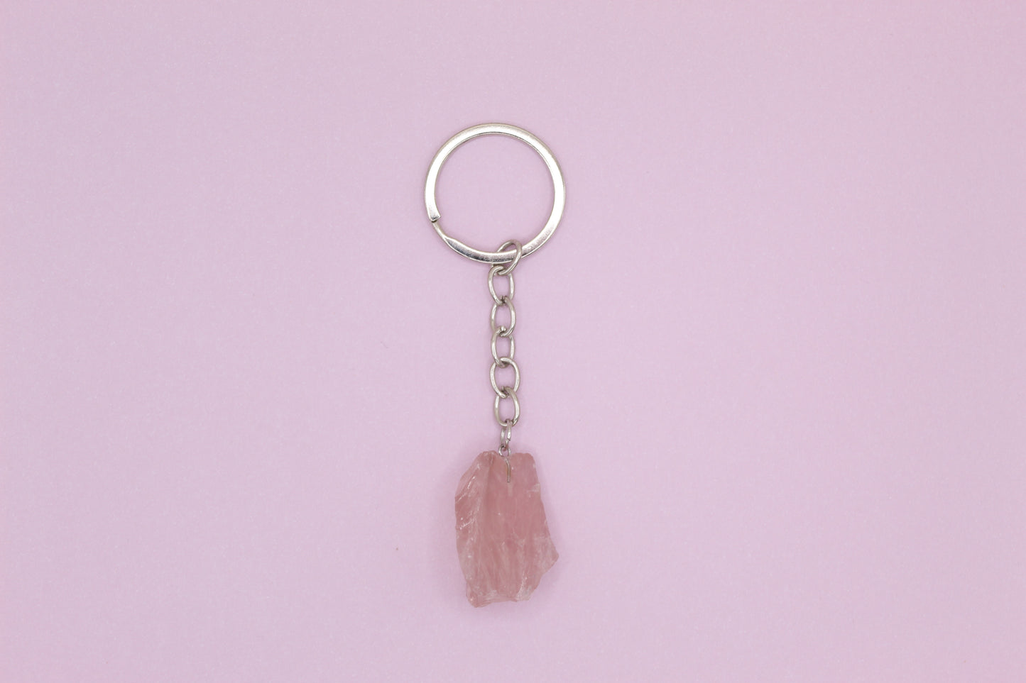 Keychain with a pink stone pendant on a light purple background