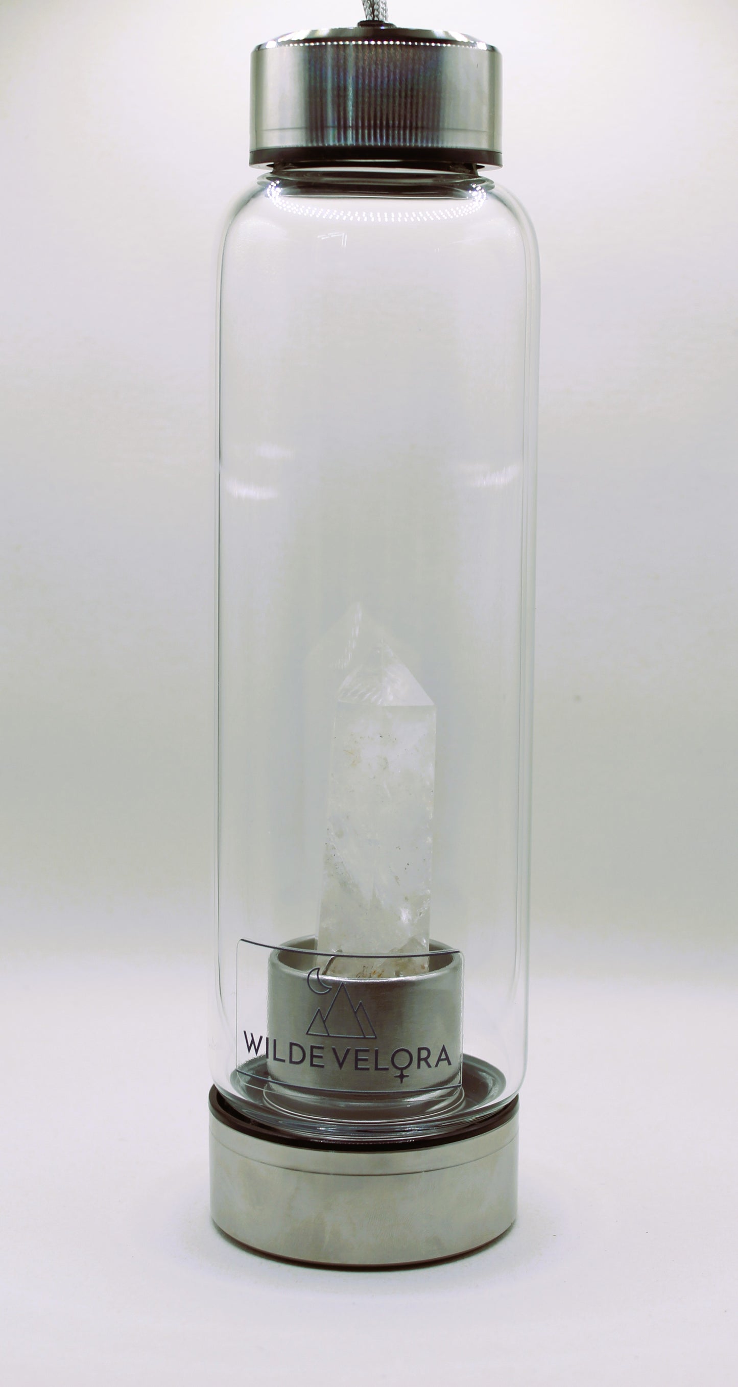 Clear glass bottle with metal cap and base on a white background