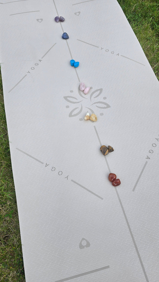 healing crystals for the 7 chakra points arranged on a yoga mat for crystal healing.