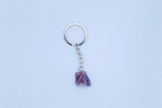 Keychain with a purple stone on a light blue background