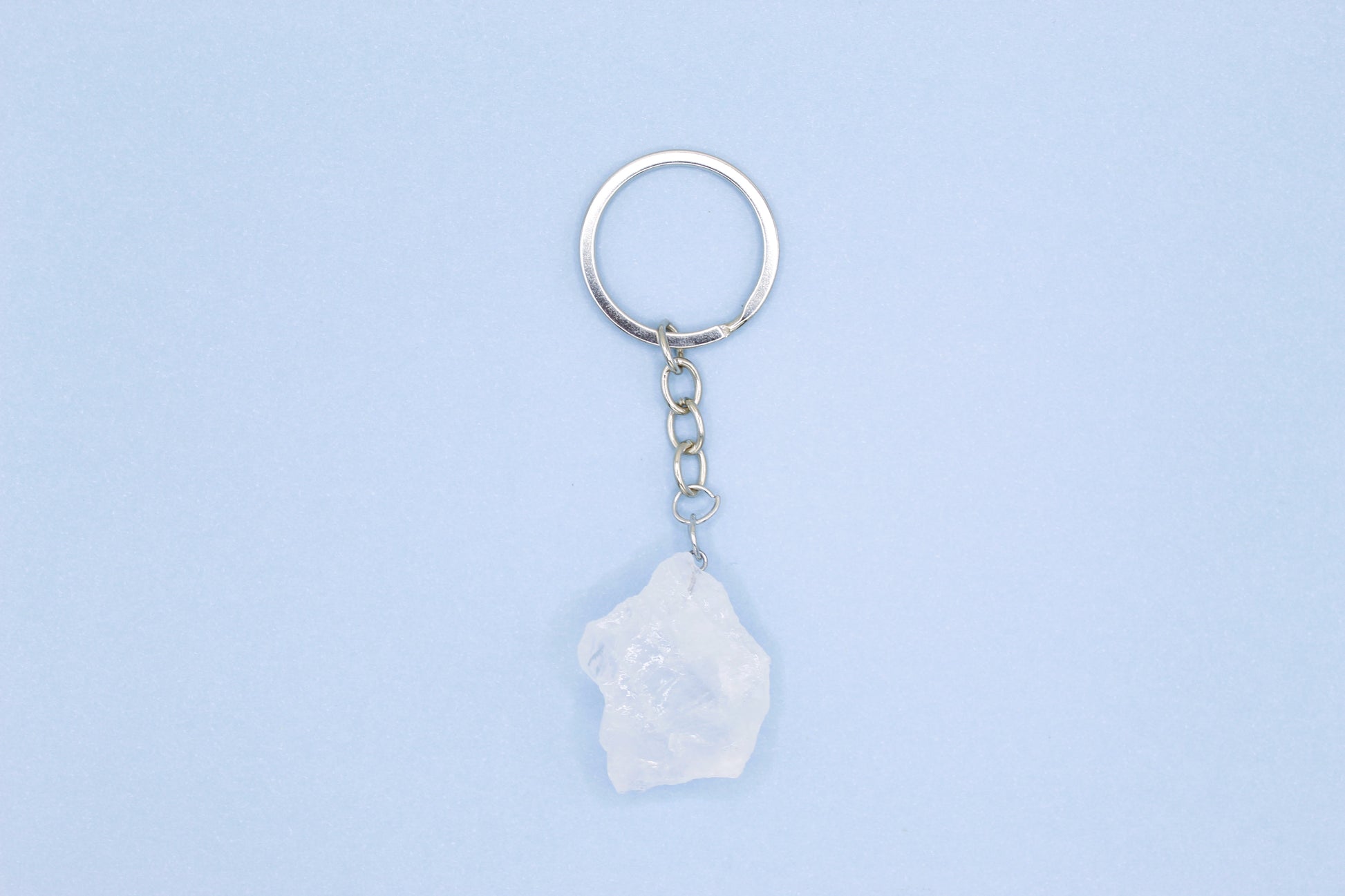 Keychain with a white stone pendant on a light blue background