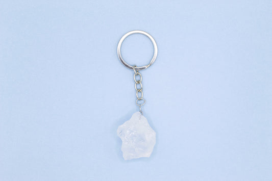 Keychain with a white stone pendant on a light blue background