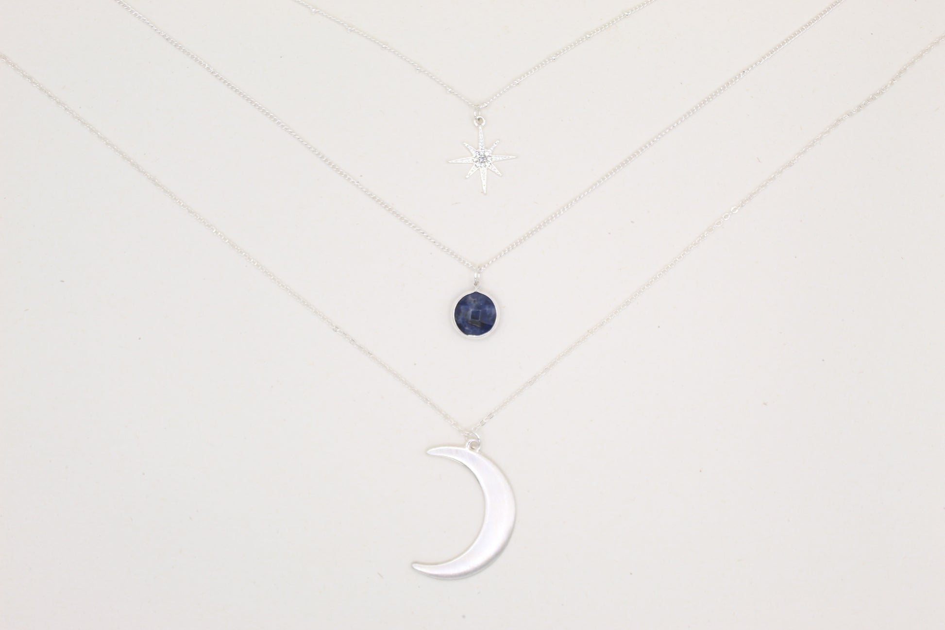 Necklace with a moon-shaped pendant on a light gray background