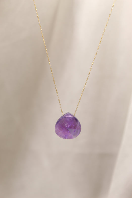 Purple gemstone necklace on a beige background