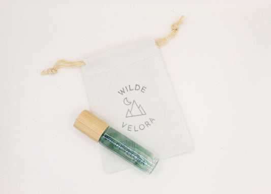 Green rollerball with wooden applicator on a white background