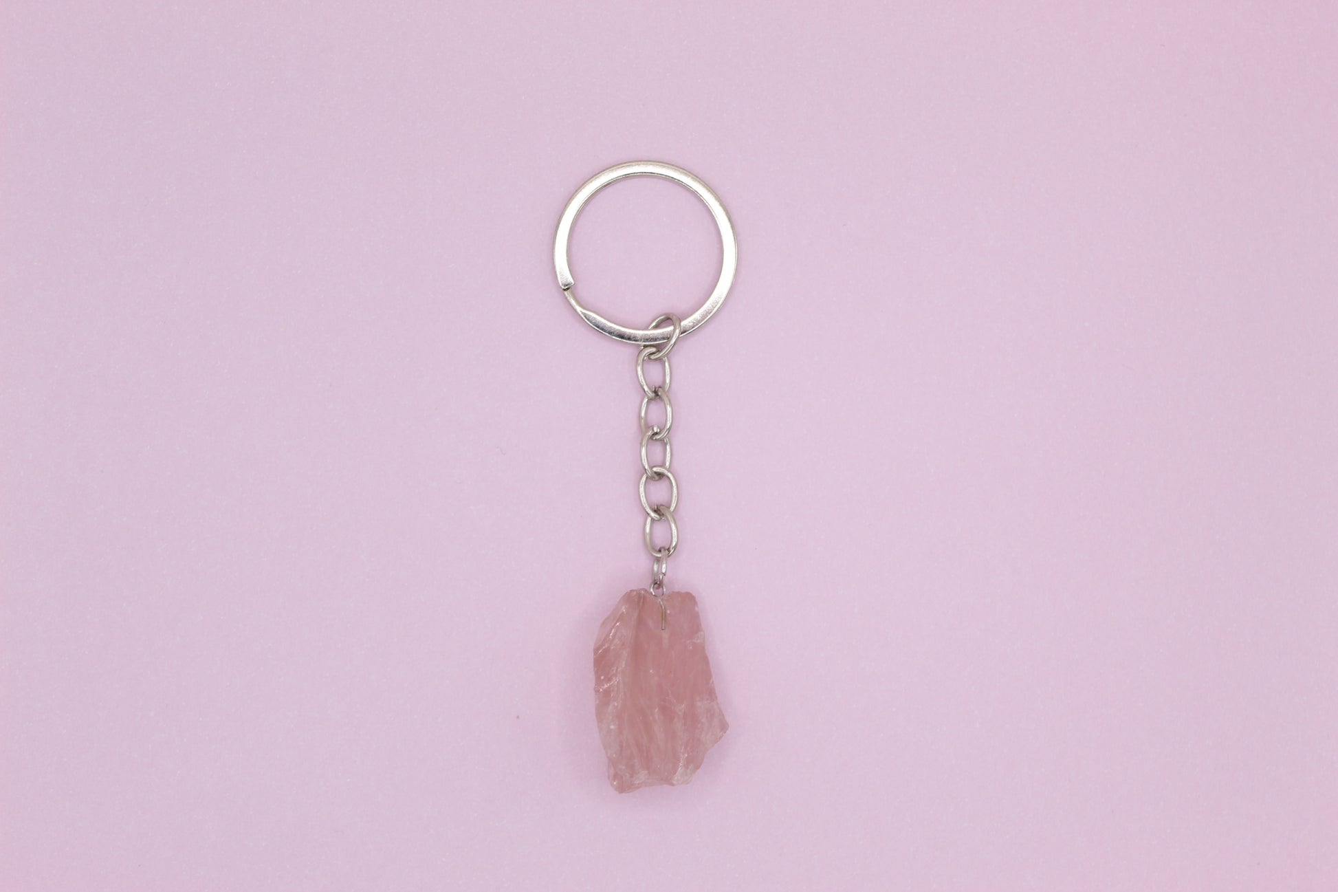 Keychain with a pink stone pendant on a light purple background