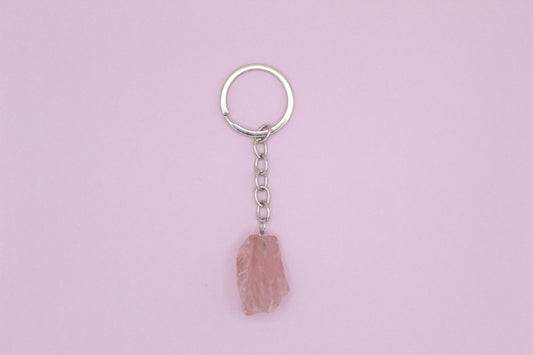 Keychain with a pink stone pendant on a light purple background