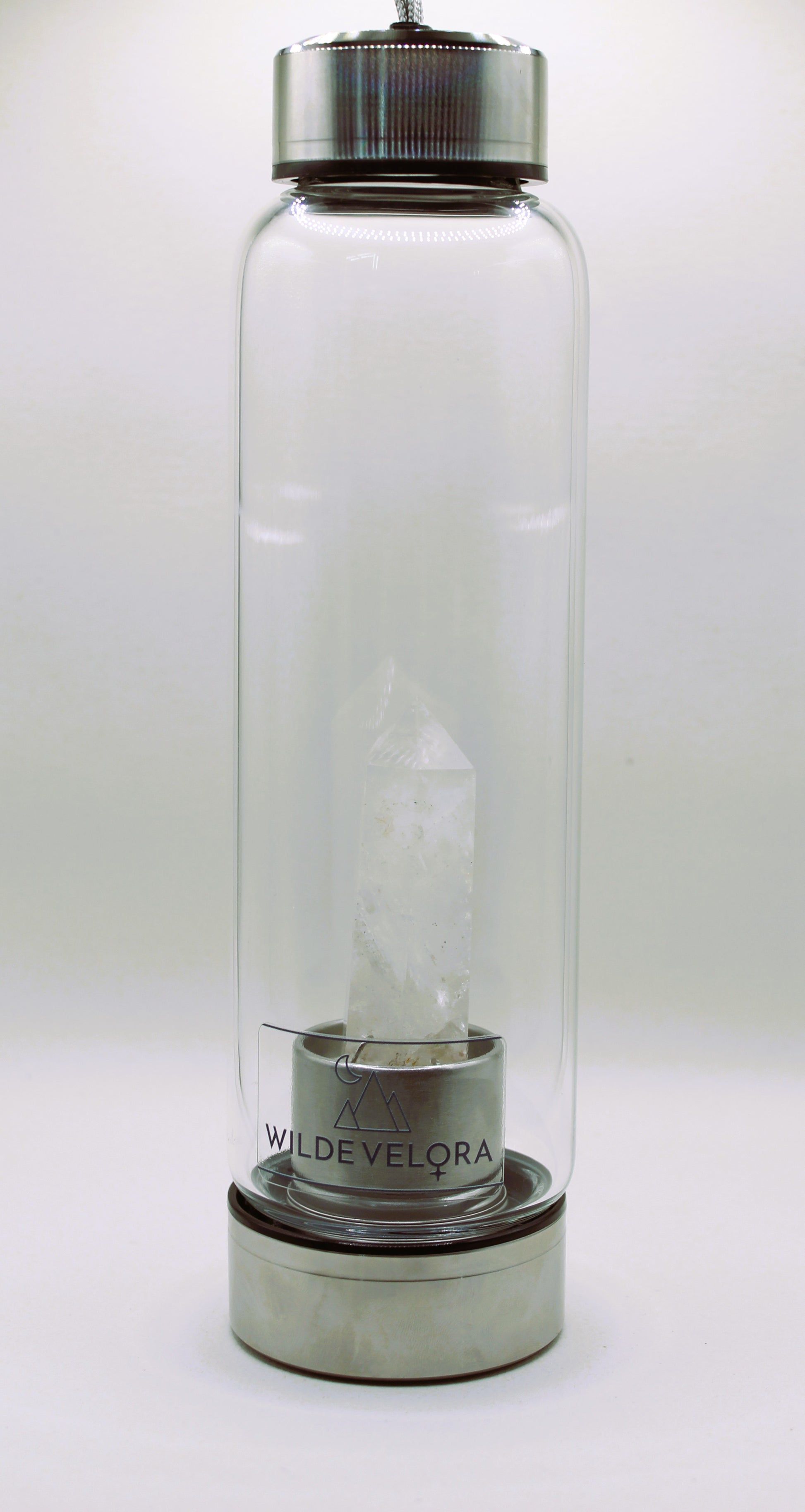Clear glass bottle with metal cap and base on a white background